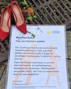 Rote Schuhe mit Gedenk-Plakat zum Femizid in Reichenbach