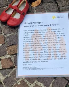 Rote Schuhe mit Gedenk-Plakat zum Femizid in Unterensingen